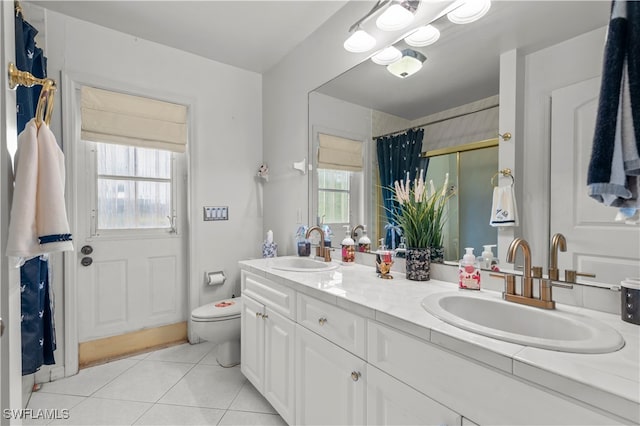 bathroom with tile patterned flooring, plenty of natural light, vanity, and toilet