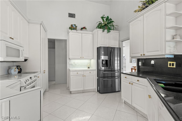 kitchen featuring white cabinetry, white appliances, backsplash, and light tile patterned floors