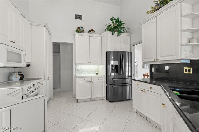 837 SW 2nd Ave, Cape Coral, FL 33991 - kitchen with white appliances, open shelves, decorative backsplash, white cabinetry, and light tile patterned floors
