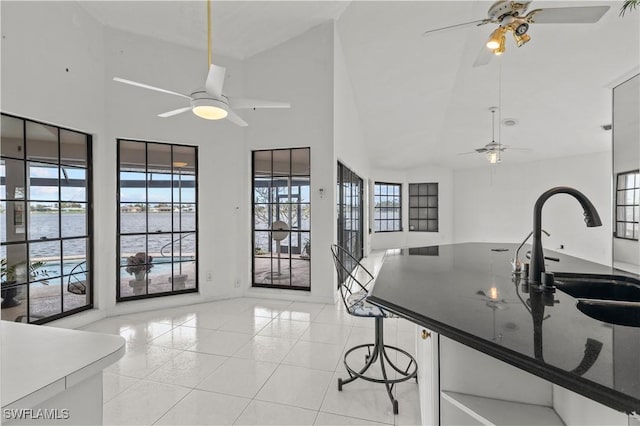 837 SW 2nd Ave, Cape Coral, FL 33991 - kitchen featuring a ceiling fan, light tile patterned floors, open floor plan, high vaulted ceiling, and dark countertops