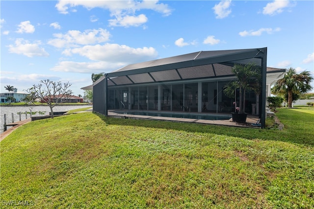 rear view of property with a water view, glass enclosure, and a yard