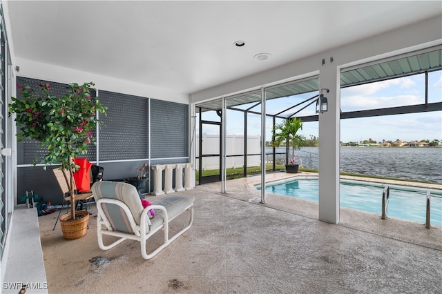 view of pool with glass enclosure, a water view, and a patio area