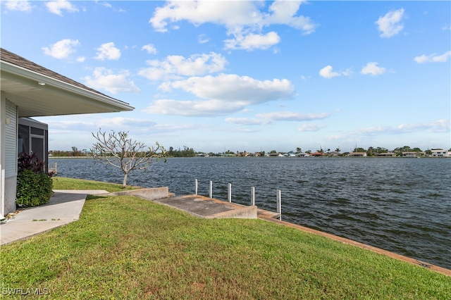 dock area with a water view and a lawn