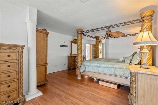 bedroom with ceiling fan, hardwood / wood-style flooring, and ornate columns