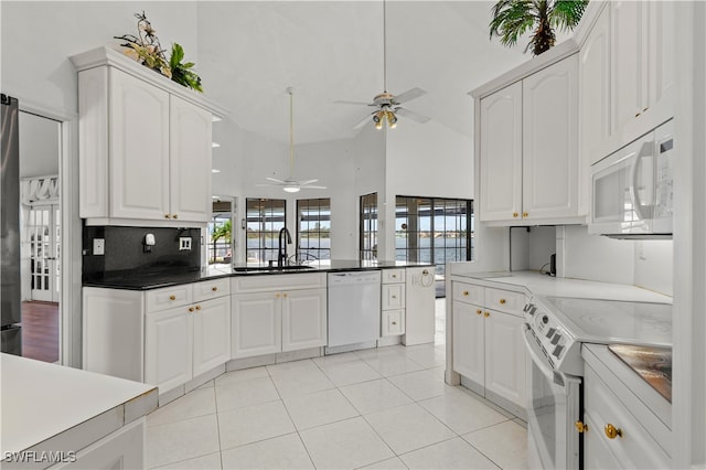 kitchen featuring white cabinetry, light tile patterned floors, decorative backsplash, sink, and white appliances