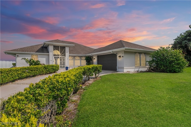 view of front of home featuring a garage and a lawn