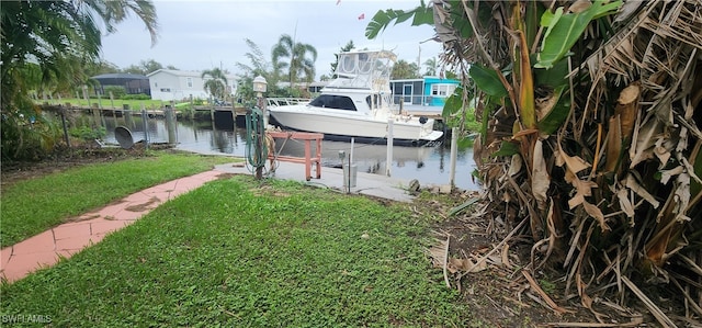 view of dock featuring a water view and a yard