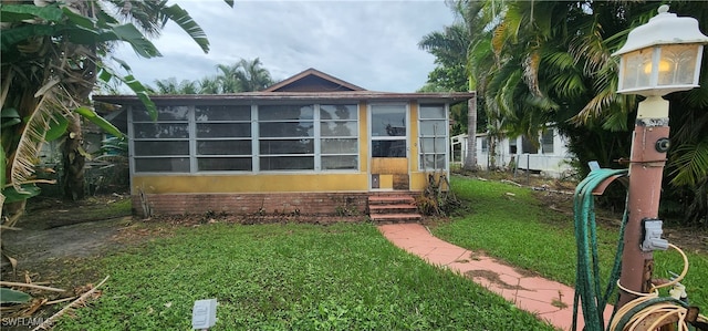 view of front of property with a front yard and a sunroom