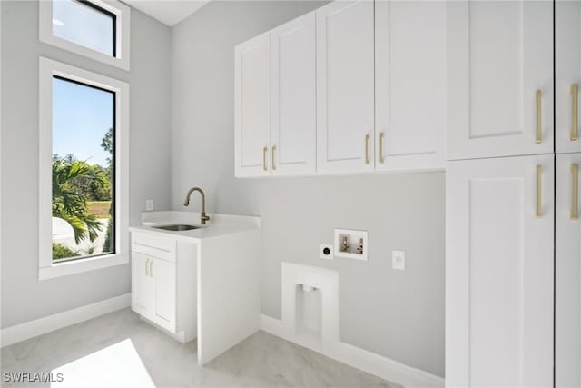 washroom with hookup for an electric dryer, plenty of natural light, cabinets, and sink