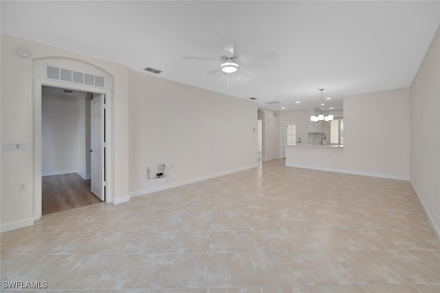 tiled empty room with ceiling fan with notable chandelier and sink