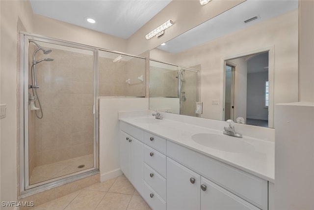 bathroom with tile patterned floors, a shower with door, and vanity