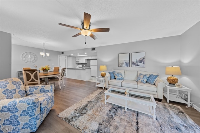 living room featuring a textured ceiling, ceiling fan with notable chandelier, and dark hardwood / wood-style floors