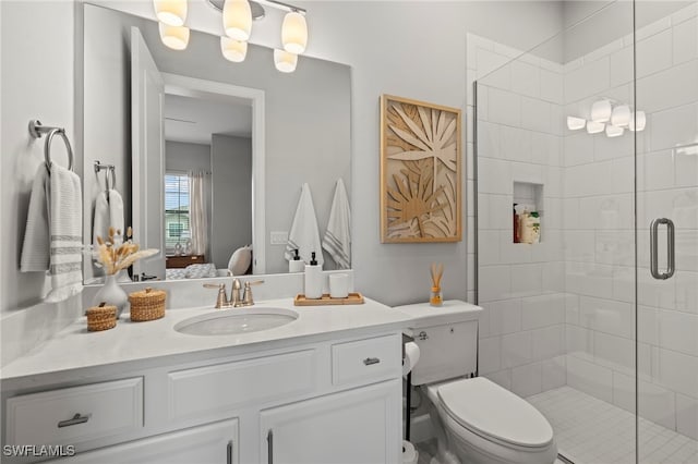 bathroom featuring vanity, toilet, and a shower with door