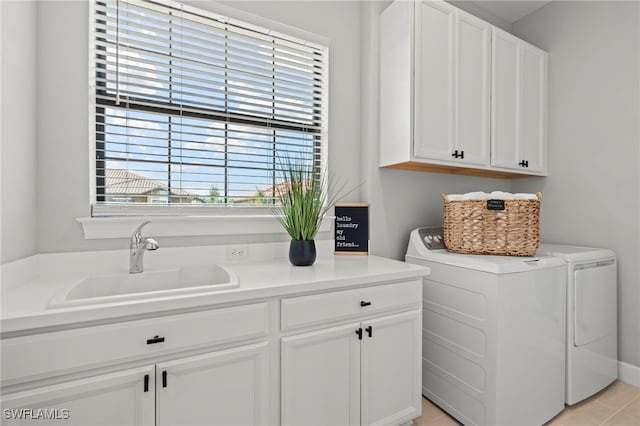 clothes washing area featuring independent washer and dryer, cabinets, sink, and light tile patterned floors