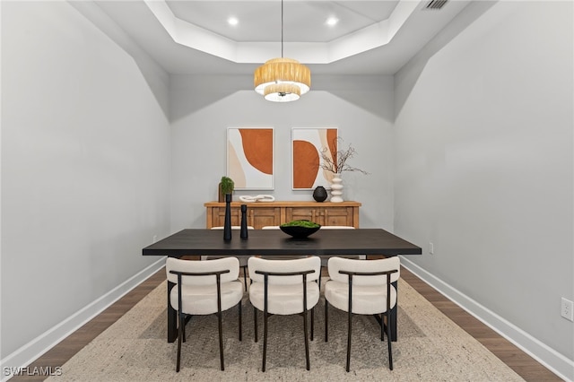 interior space featuring dark hardwood / wood-style floors, a notable chandelier, and a tray ceiling