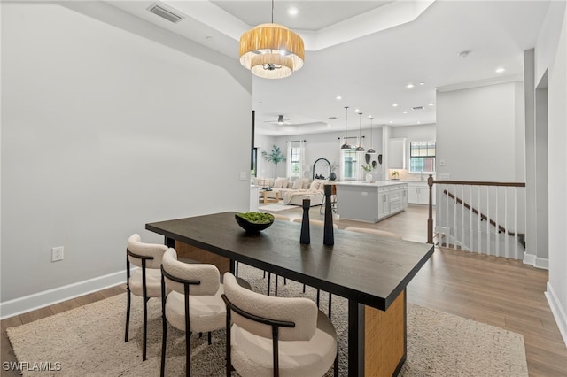 dining room with light hardwood / wood-style floors and a chandelier