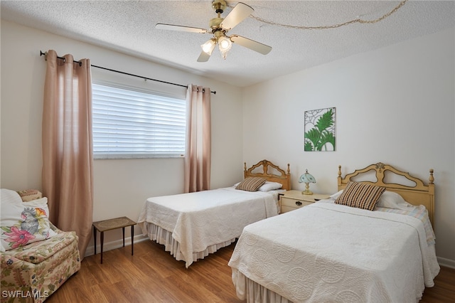 bedroom featuring ceiling fan, a textured ceiling, and light wood-type flooring