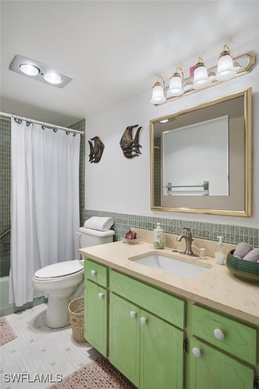 bathroom with toilet, vanity, tile patterned floors, and tile walls