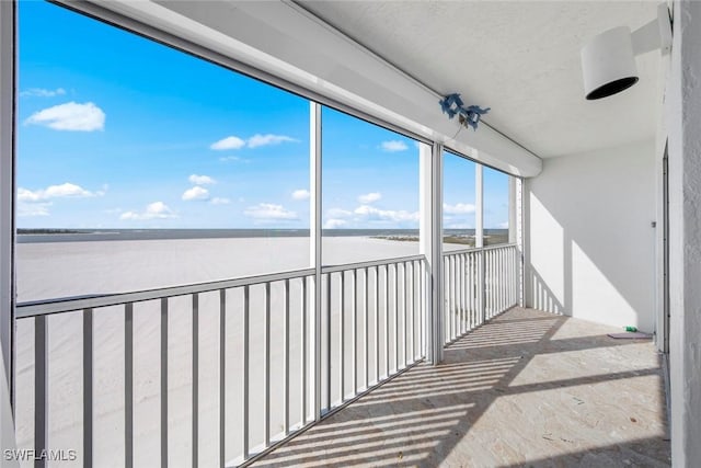 unfurnished sunroom featuring a water view