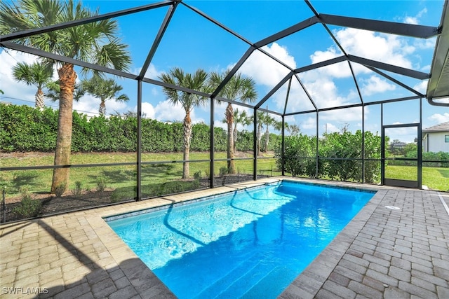 view of pool featuring glass enclosure and a patio