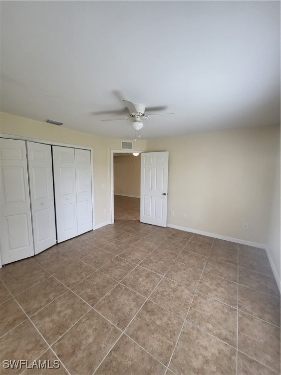 unfurnished bedroom with a closet, tile patterned flooring, and ceiling fan