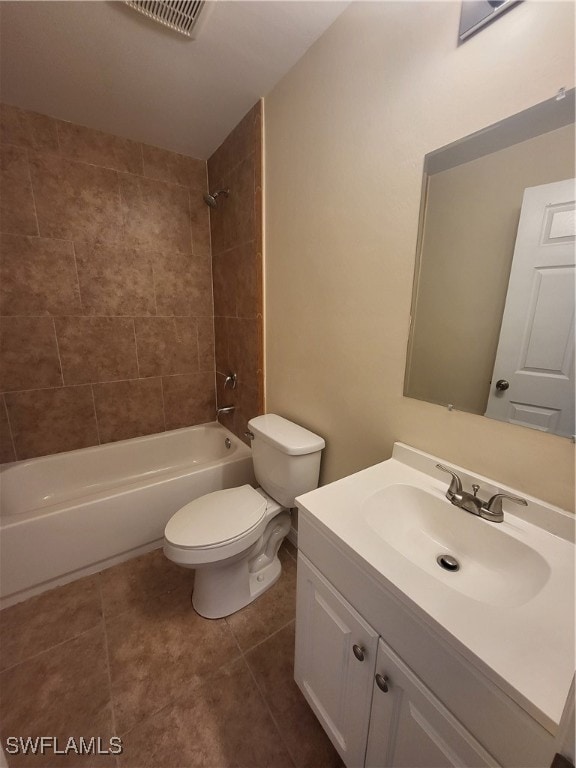 full bathroom featuring vanity, tile patterned flooring, toilet, and tiled shower / bath