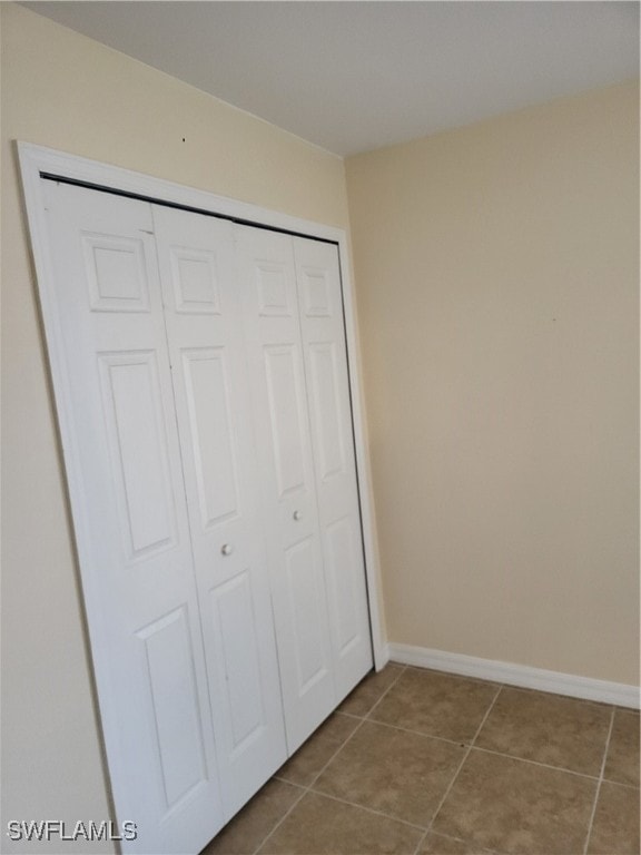 unfurnished bedroom with light tile patterned floors and a closet