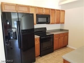 kitchen with black appliances and light tile patterned flooring