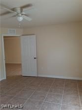 tiled spare room featuring ceiling fan