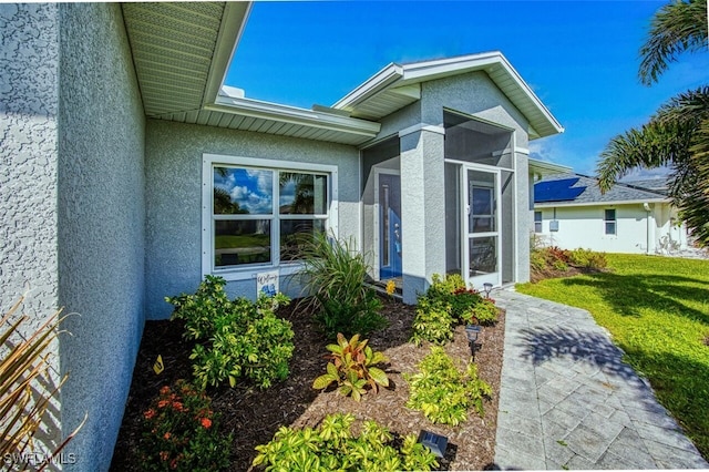 doorway to property featuring a lawn