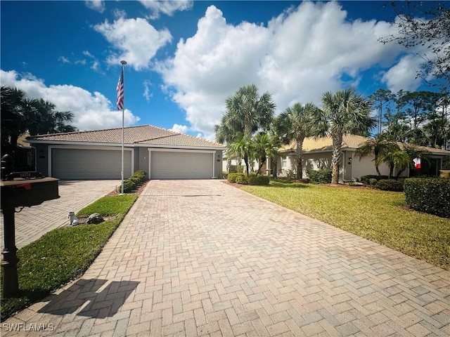 ranch-style home featuring an attached garage, a tile roof, decorative driveway, stucco siding, and a front yard