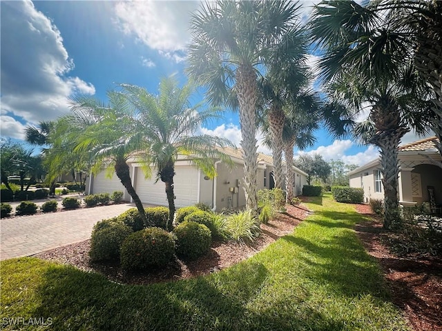 view of yard featuring decorative driveway and an attached garage