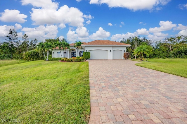 mediterranean / spanish house with a garage and a front lawn