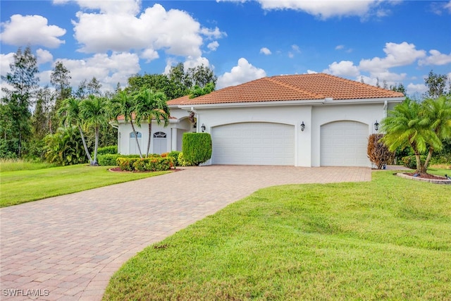 mediterranean / spanish-style house featuring a garage and a front lawn