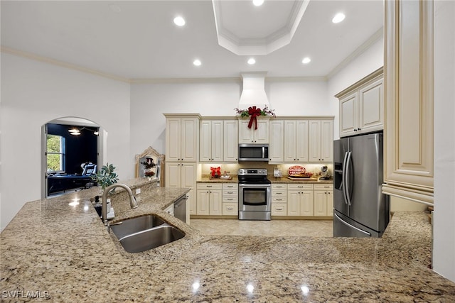 kitchen featuring appliances with stainless steel finishes, sink, cream cabinets, and crown molding