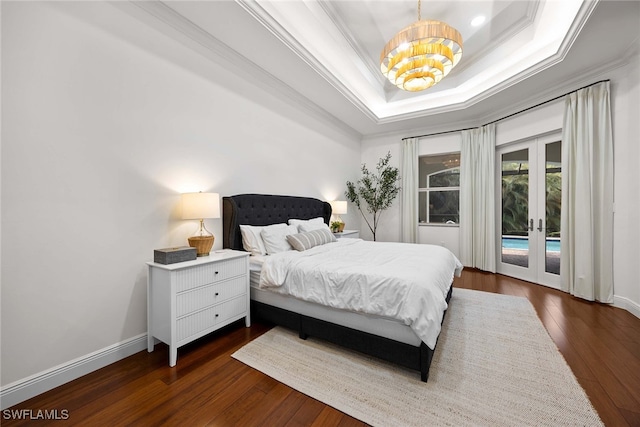 bedroom with access to exterior, a tray ceiling, crown molding, dark hardwood / wood-style flooring, and french doors