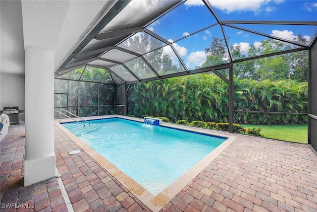 view of swimming pool with glass enclosure, pool water feature, and a patio area