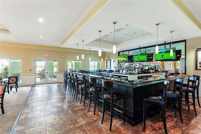 kitchen featuring hanging light fixtures, a breakfast bar, and a tray ceiling