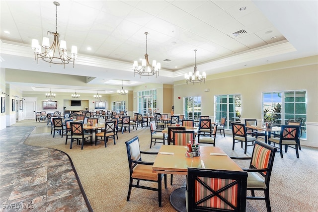 carpeted dining room with a towering ceiling, crown molding, and a raised ceiling