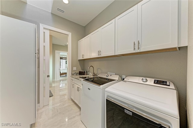 laundry area featuring cabinets, sink, and separate washer and dryer