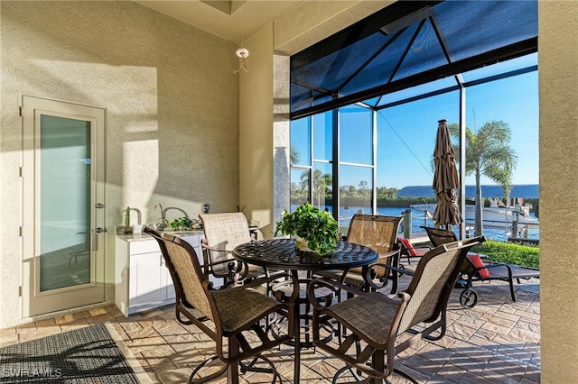 view of patio / terrace with a water view and glass enclosure