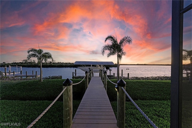 dock area with a water view and a lawn