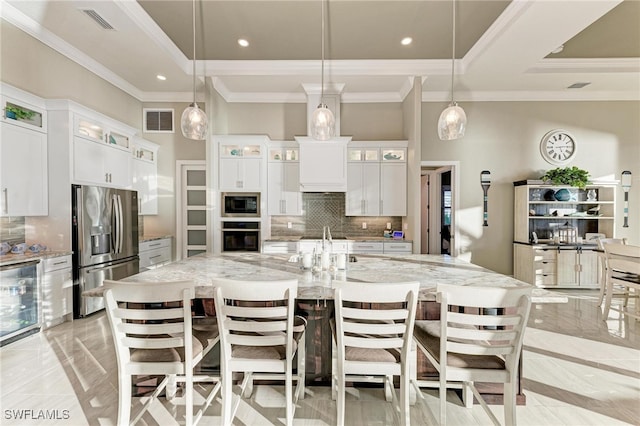 kitchen with a spacious island, white cabinetry, appliances with stainless steel finishes, and hanging light fixtures