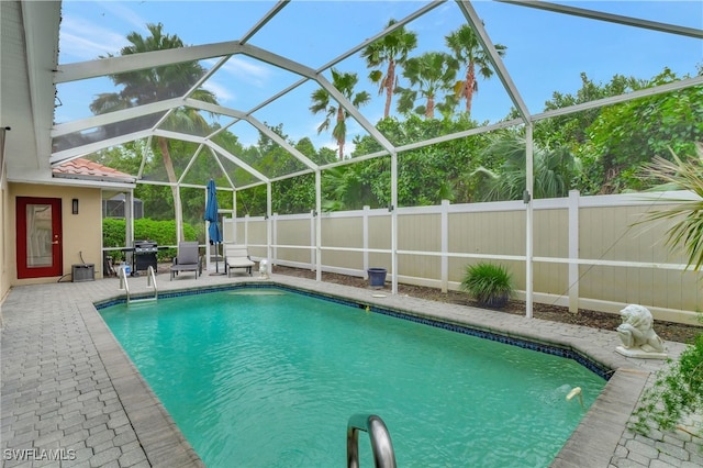 view of pool with a lanai, a patio area, and grilling area