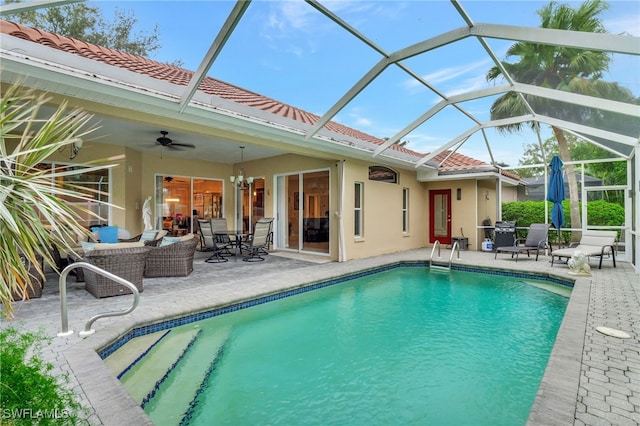 view of swimming pool featuring glass enclosure, ceiling fan, and a patio