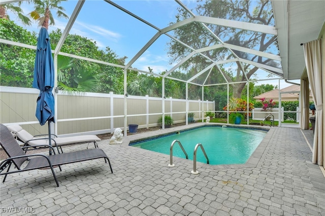 view of swimming pool featuring glass enclosure and a patio area