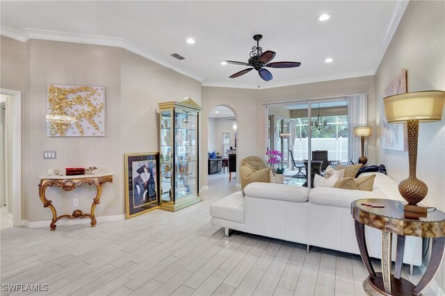 living room featuring ceiling fan, light wood-type flooring, and crown molding