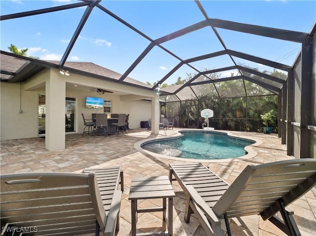 view of swimming pool featuring ceiling fan, a lanai, and a patio