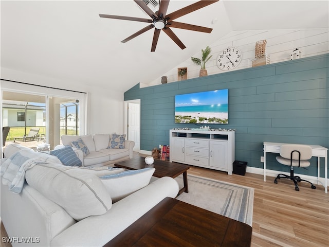 living room with ceiling fan, vaulted ceiling, and light hardwood / wood-style floors