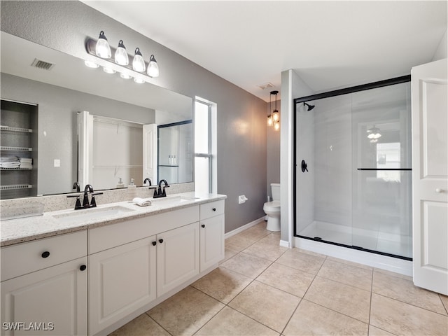 bathroom with a shower with shower door, tile patterned floors, vanity, and toilet